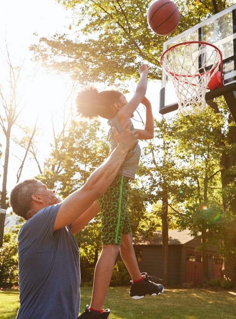 Parent and child playing basketball